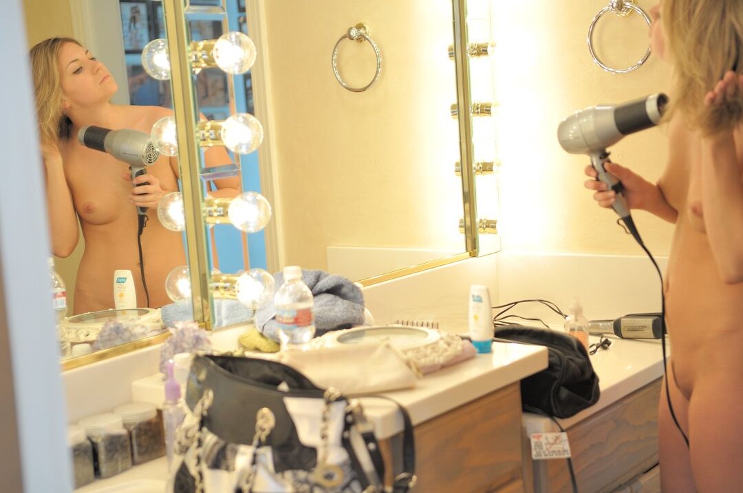 21P Stephanie, une jeune blonde aux petits seins, exhibe son corps tout en se séchant les cheveux.