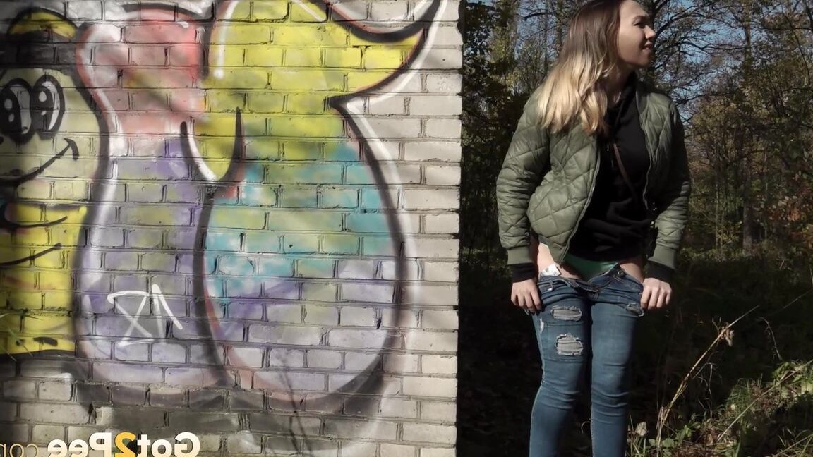 15P Kurz entführtes Mädchen zieht ihre Jeans herunter, um an einem Backsteingebäude zu pinkeln