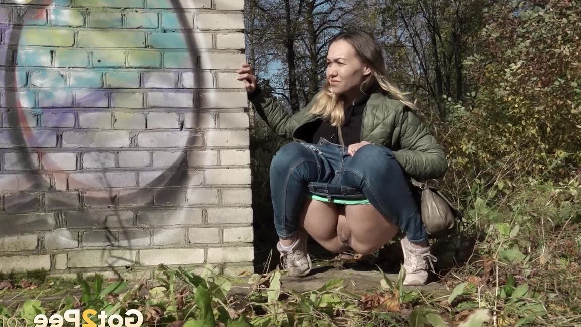 15P Kurz entführtes Mädchen zieht ihre Jeans herunter, um an einem Backsteingebäude zu pinkeln