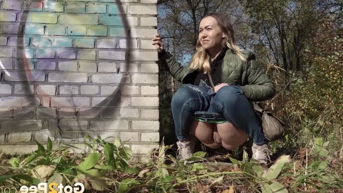 15P Kurz entführtes Mädchen zieht ihre Jeans herunter, um an einem Backsteingebäude zu pinkeln