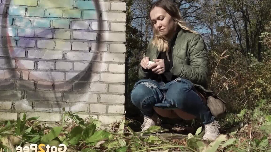 15P Kurz entführtes Mädchen zieht ihre Jeans herunter, um an einem Backsteingebäude zu pinkeln