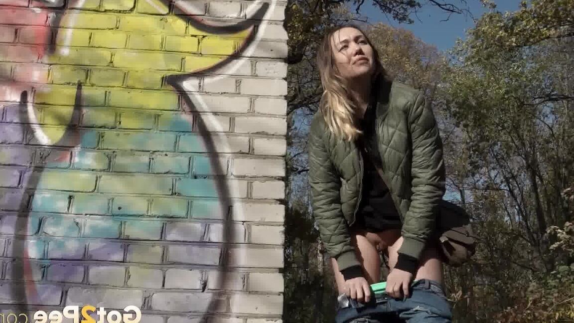 15P Kurz entführtes Mädchen zieht ihre Jeans herunter, um an einem Backsteingebäude zu pinkeln