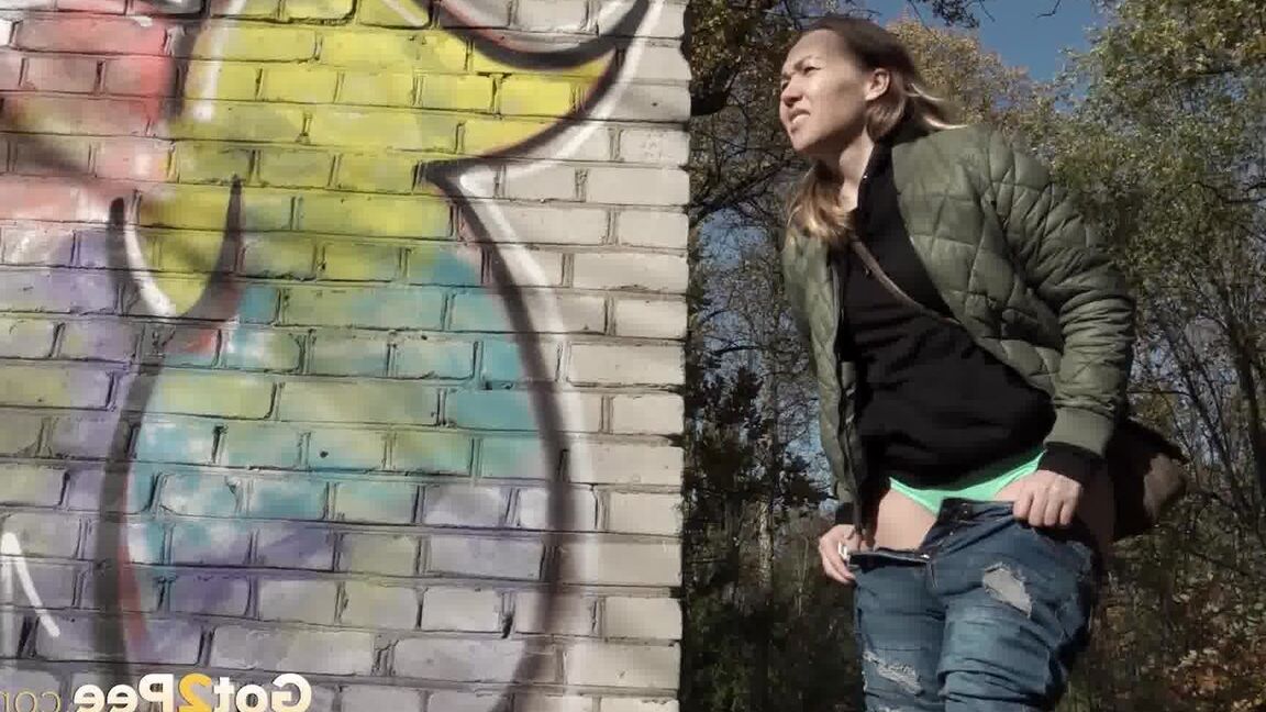 15P Kurz entführtes Mädchen zieht ihre Jeans herunter, um an einem Backsteingebäude zu pinkeln