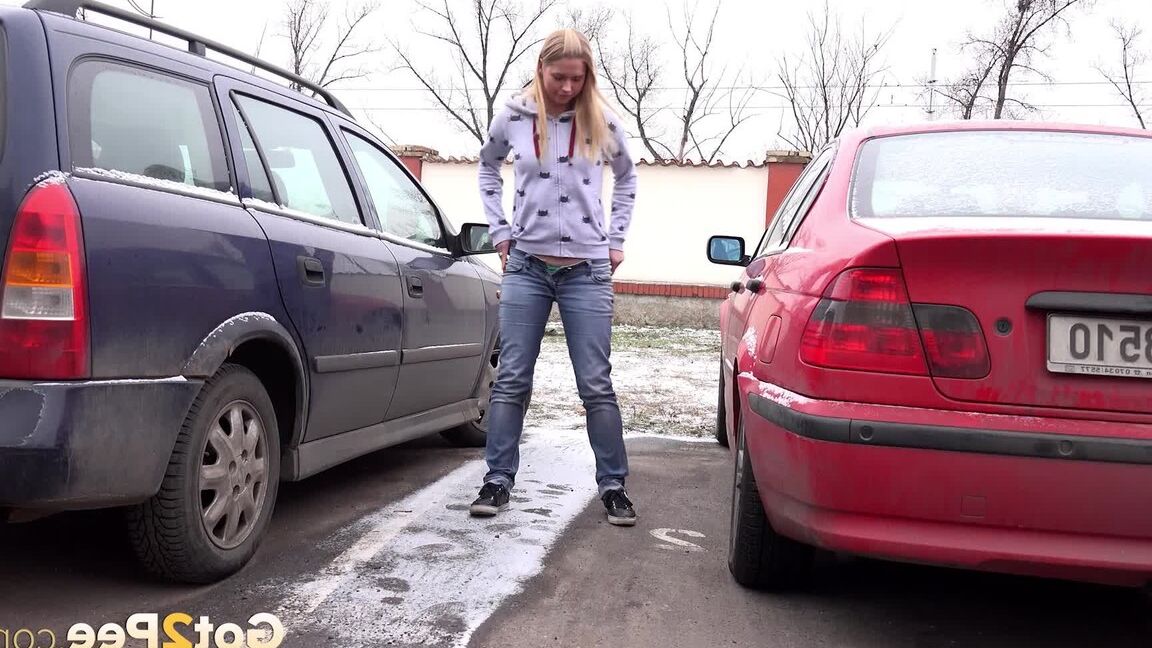 15P Blonde girl Violette squats for a pee between parked cars in the winter