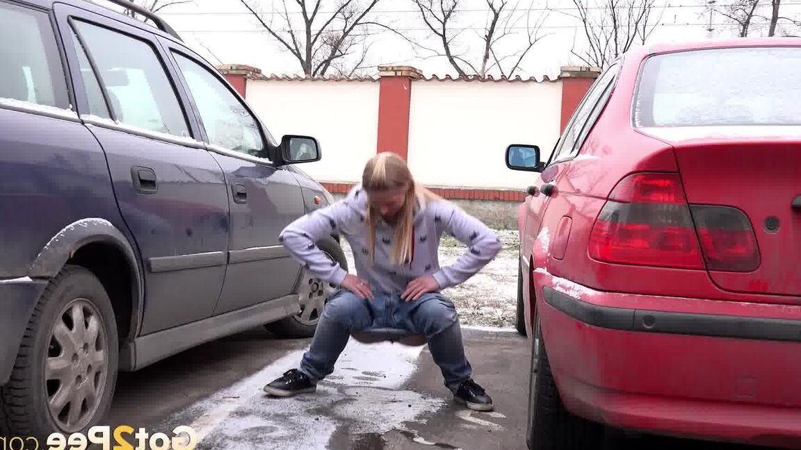 15P Blonde girl Violette squats for a pee between parked cars in the winter