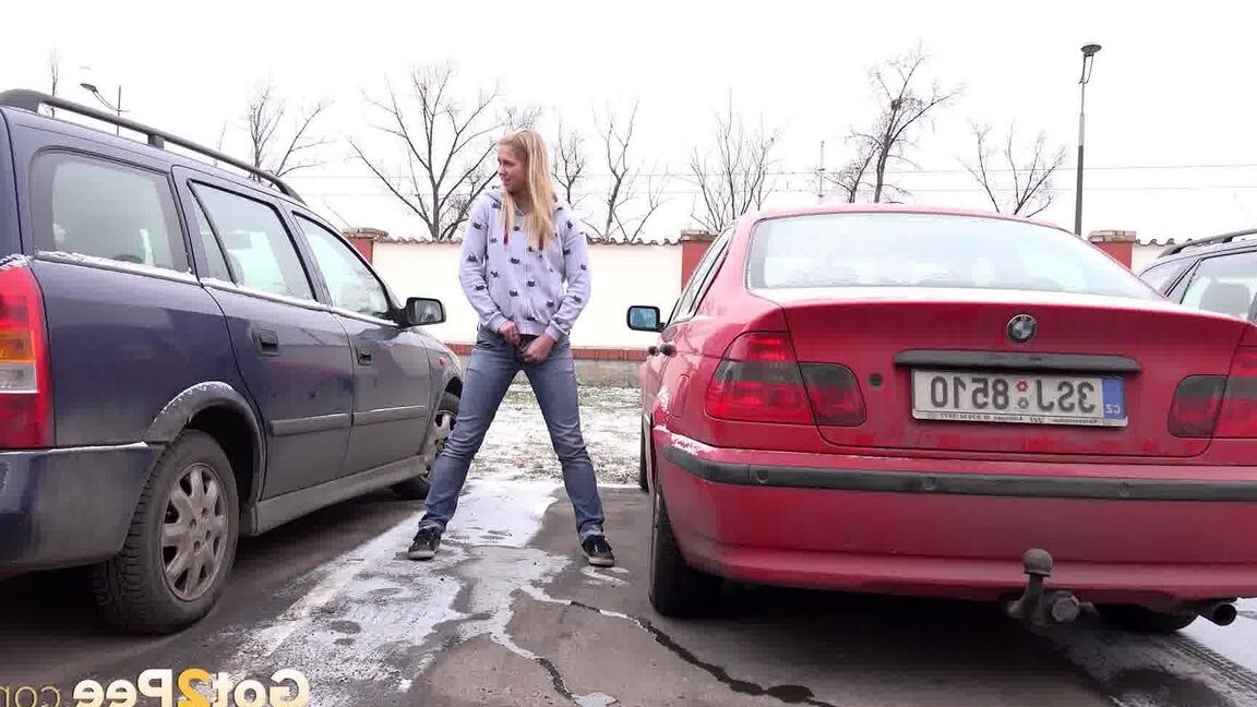 15P Blonde girl Violette squats for a pee between parked cars in the winter