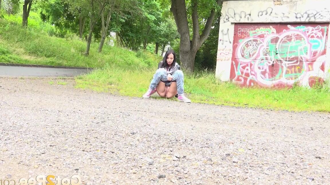15P Solo girl with black hair squats for a piss on the side of a dirt road