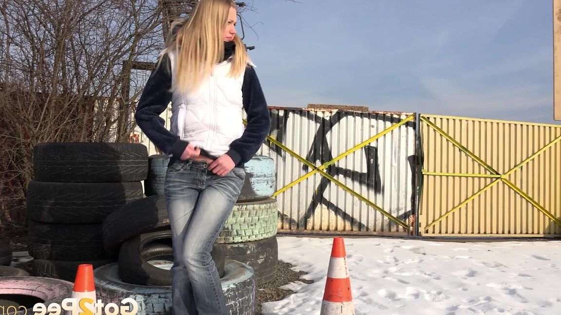 15P Blonde chick Violette pulls down her jeans to pee in the snow by a junkyard