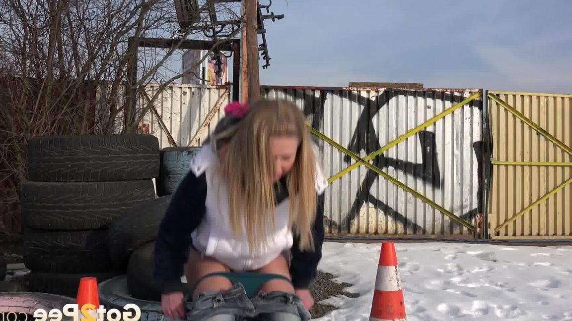 15P Blonde chick Violette pulls down her jeans to pee in the snow by a junkyard