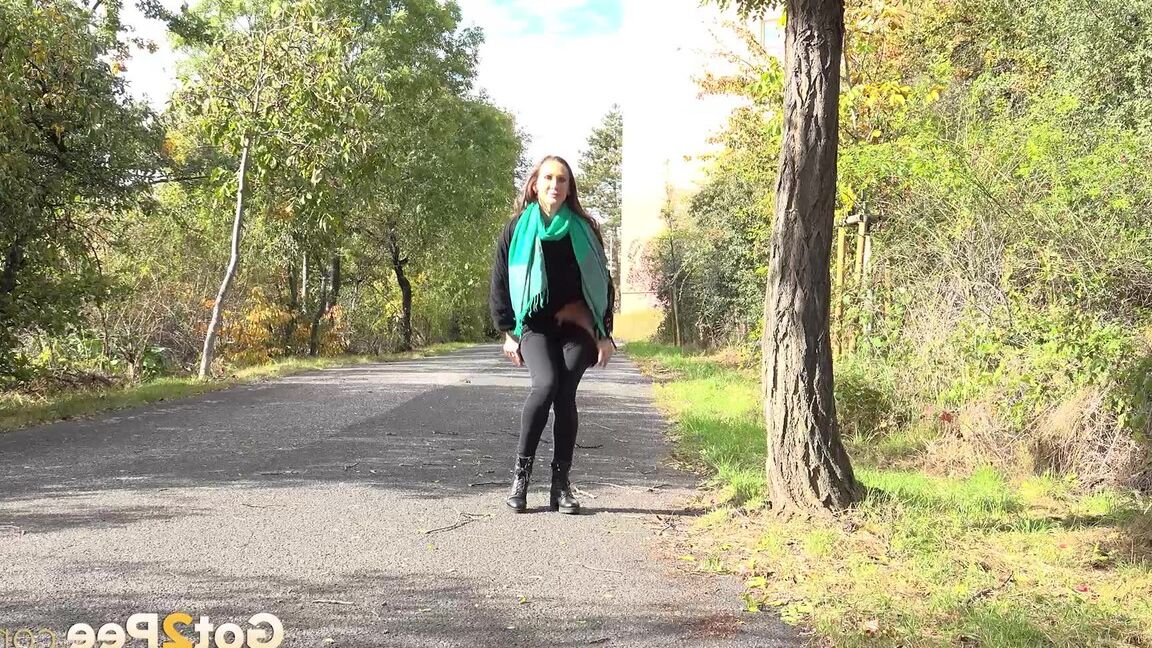 15P Caucasian girl Cynthia Vellons takes a piss while walking along a paved road