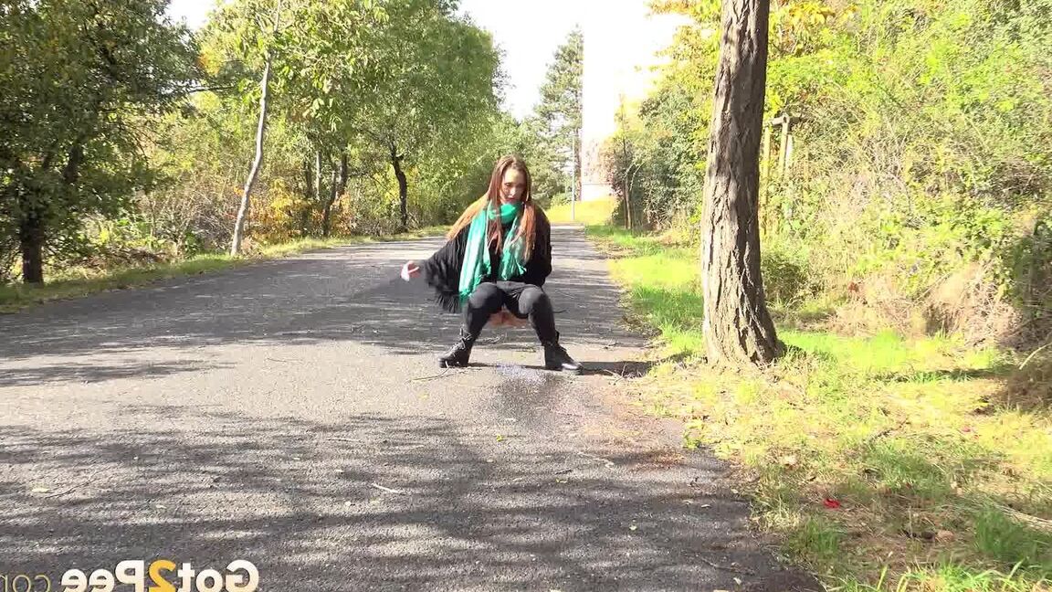 15P Caucasian girl Cynthia Vellons takes a piss while walking along a paved road