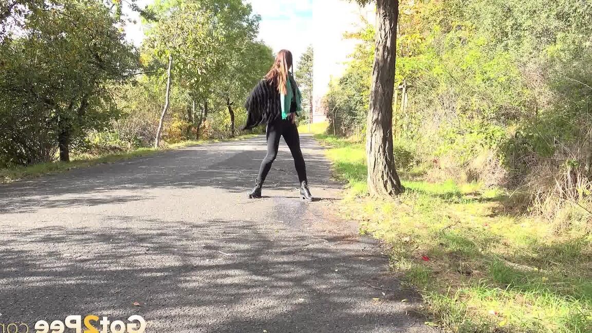 15P Caucasian girl Cynthia Vellons takes a piss while walking along a paved road
