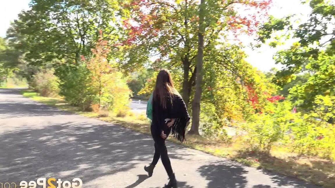 15P Caucasian girl Cynthia Vellons takes a piss while walking along a paved road