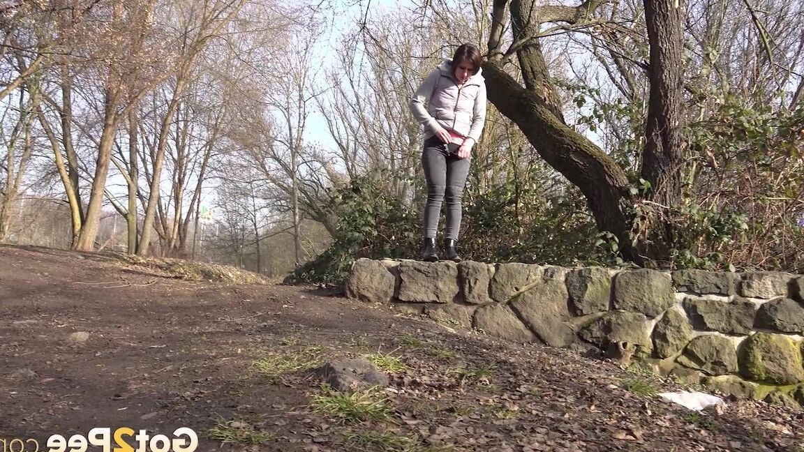 15P Lara Fox squats to pee on a stone wall
