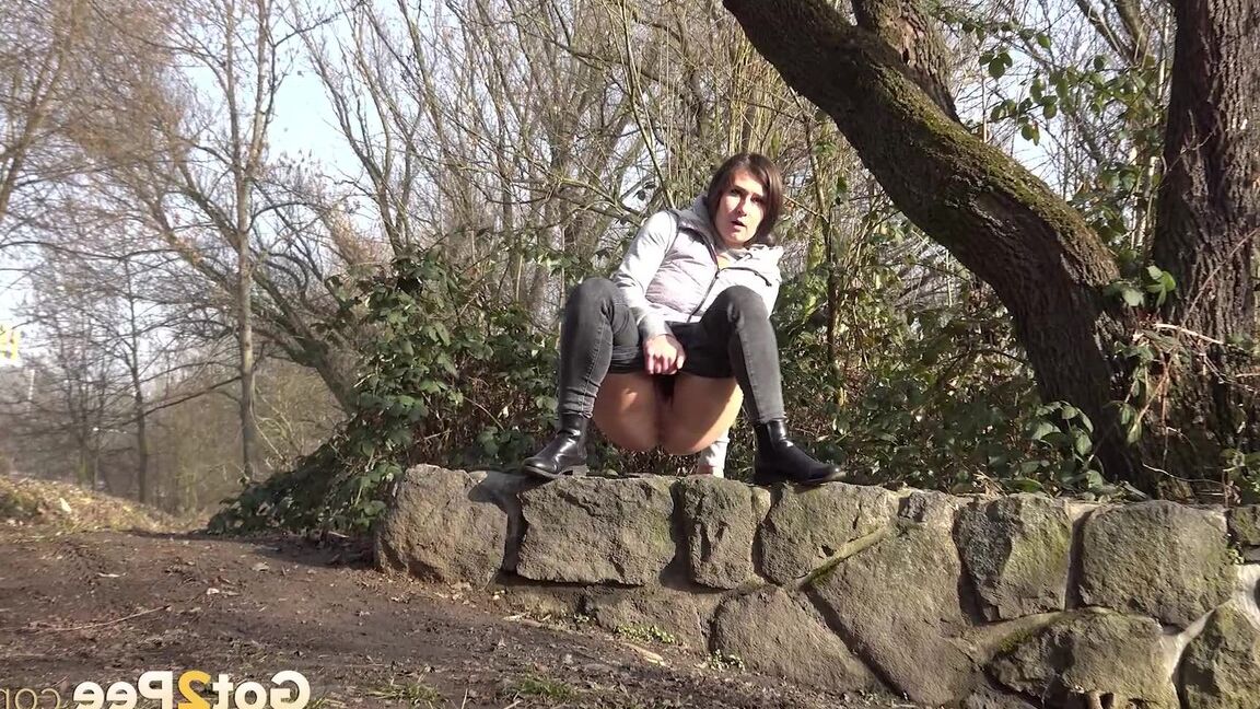 15P Lara Fox squats to pee on a stone wall