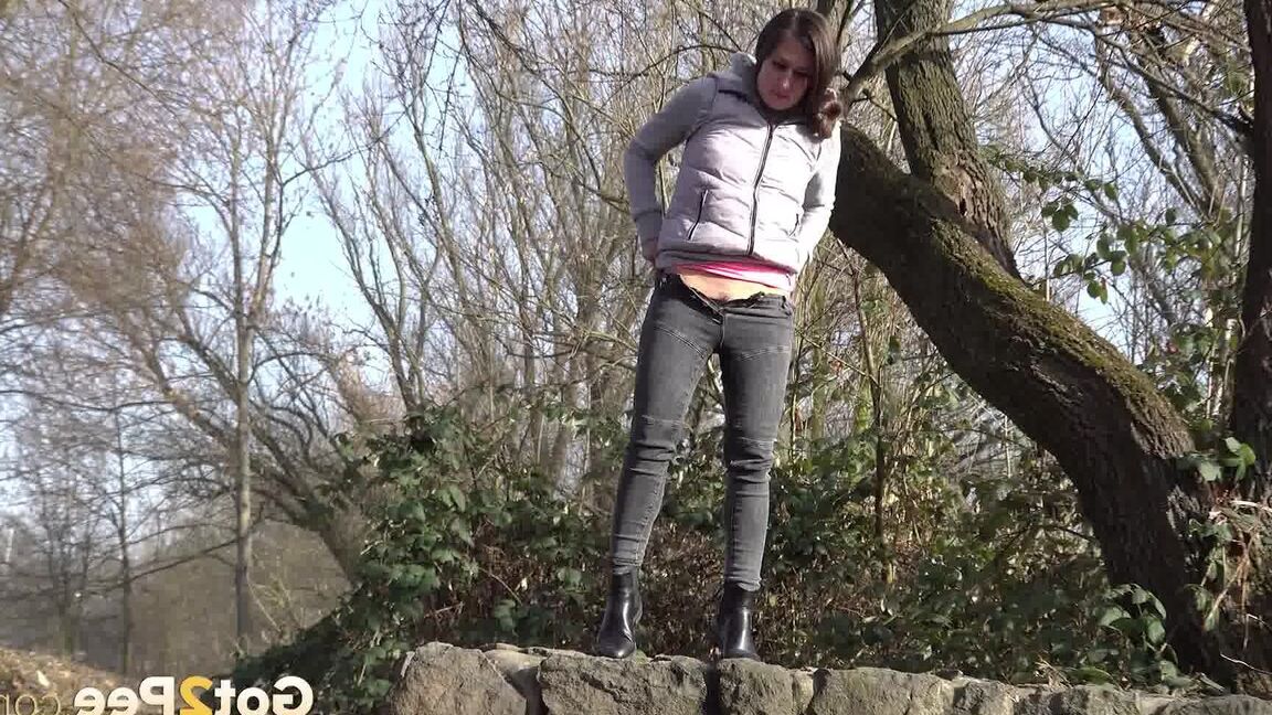 15P Lara Fox squats to pee on a stone wall