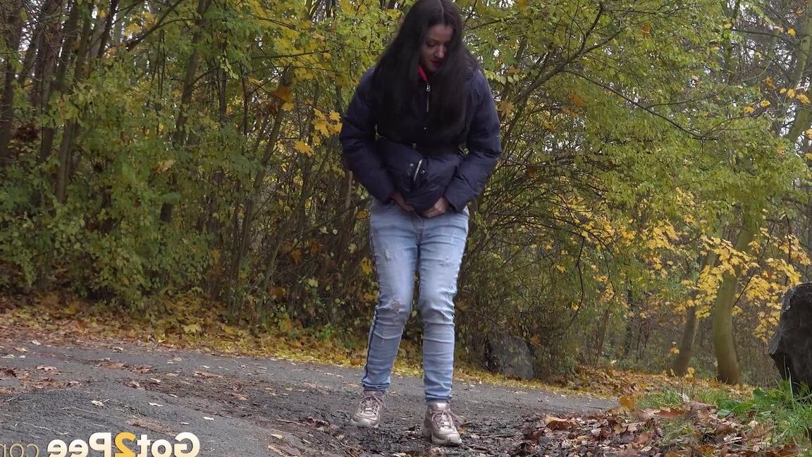 15P Garota de cabelos escuros abaixa a calça jeans para mijar enquanto sai para passear