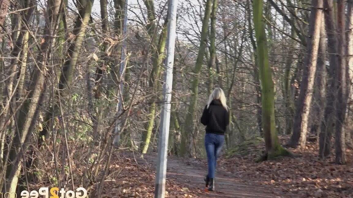 15P Blonde chick Claudia Macc pyulls down jeans for a pee on path in the forest