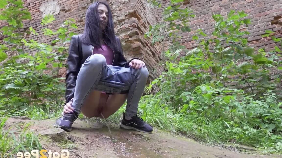 15P Dark-haired teen Natasha pulls down her jeans to pee on a patch of ground