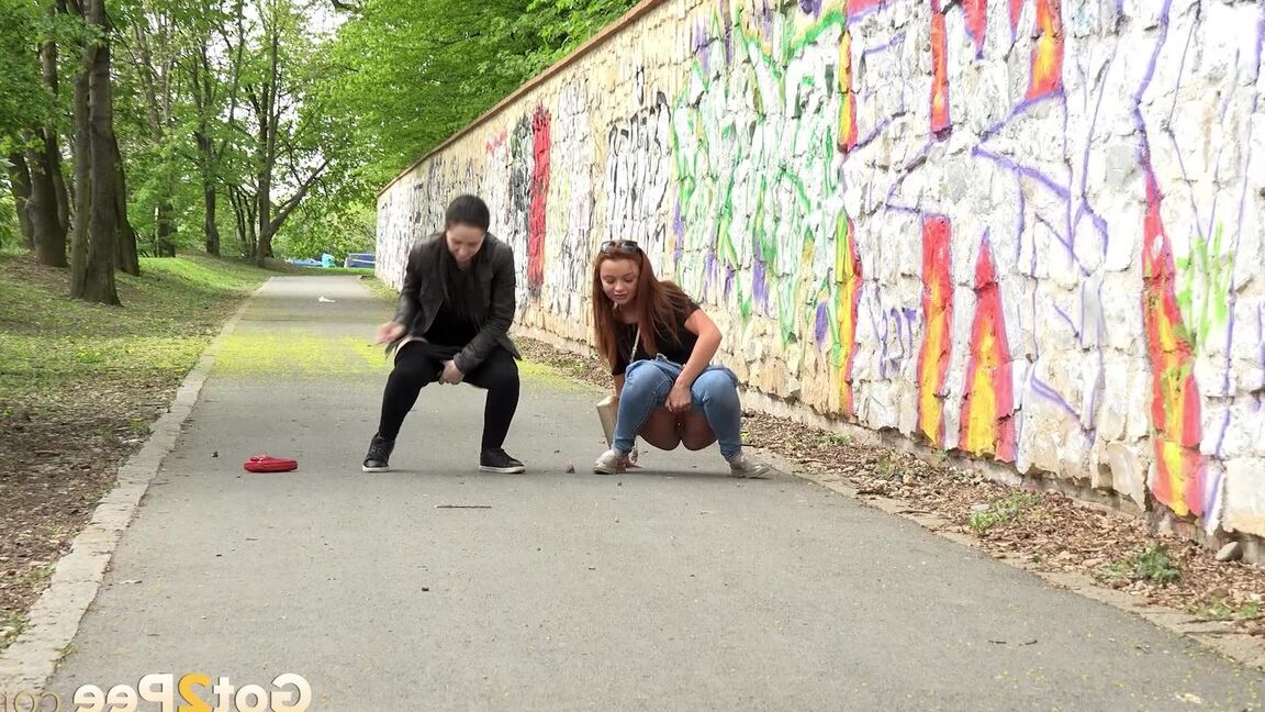 15P Two girls pull down their pants in order to piss on the road