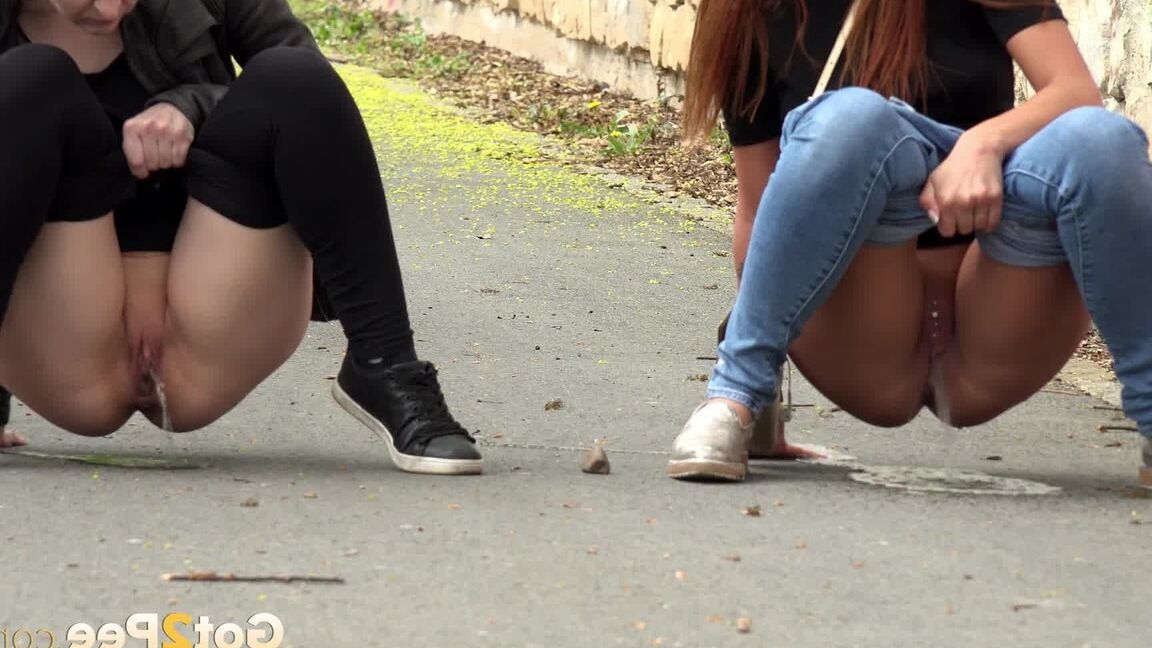 15P Two girls pull down their pants in order to piss on the road