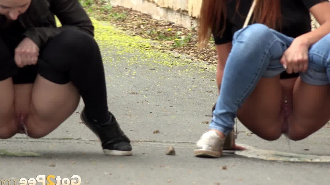 15P Two girls pull down their pants in order to piss on the road