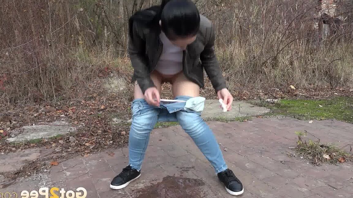 15P La femme vêtue, Corin, baisse son jean pour pisser d'urgence sur un terrain vague