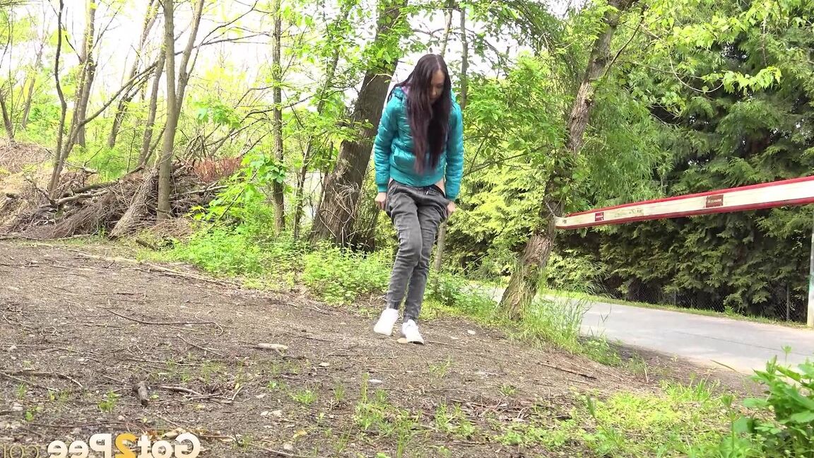 15P Short taken girl squats to be on a path in the woods while wearing a coat