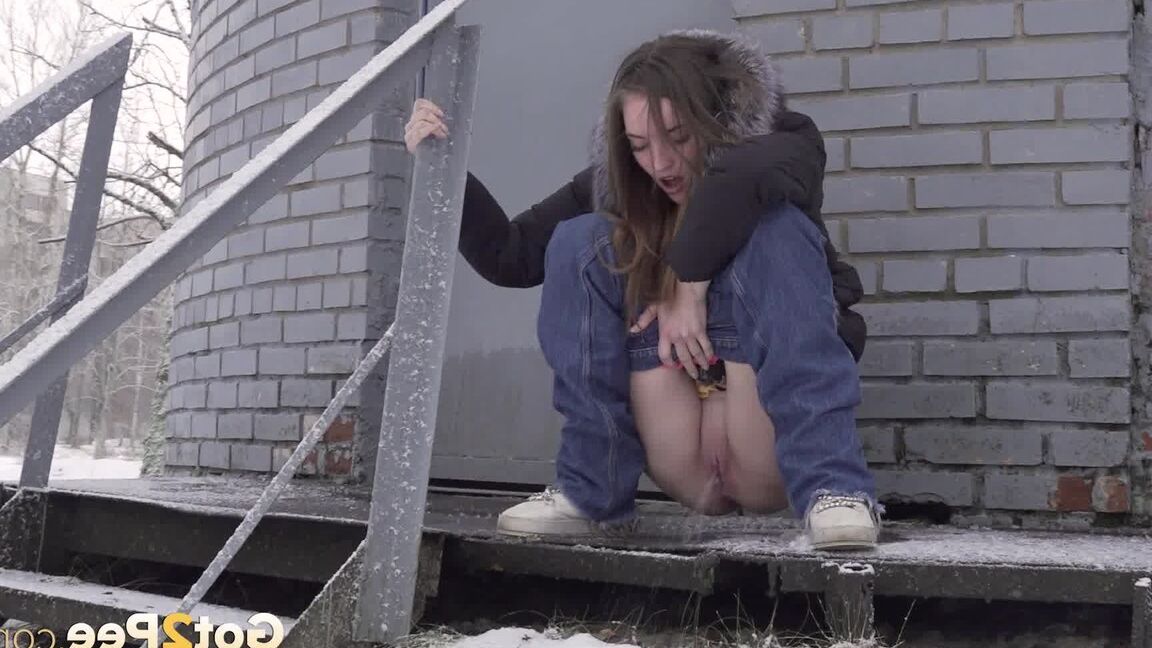 15P 白人の女の子が建物の裏の雪の中でジーンズを下ろしておしっこする