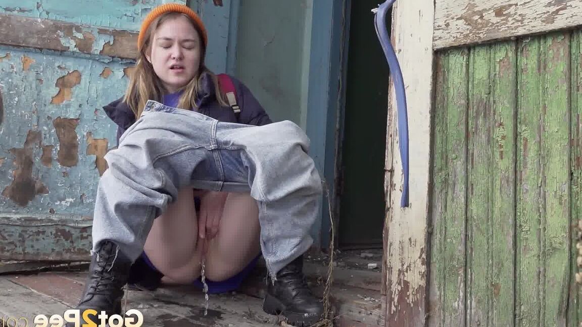 15P Cute girl pulls down jeans for an urgent piss on the steps of an old building