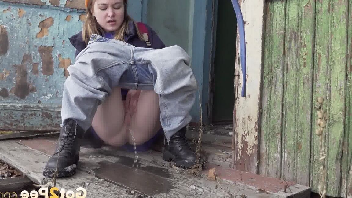 15P Cute girl pulls down jeans for an urgent piss on the steps of an old building