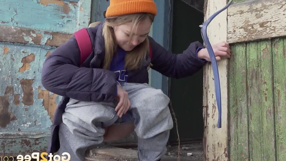 15P Cute girl pulls down jeans for an urgent piss on the steps of an old building