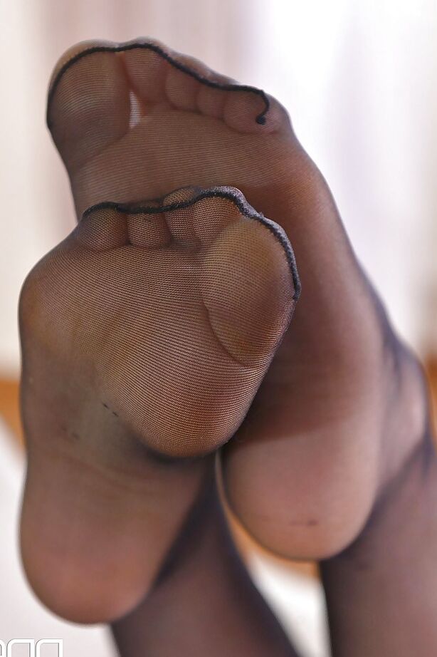 16P Nena europea de piernas largas quitándose los tacones altos de los pies adornados con medias