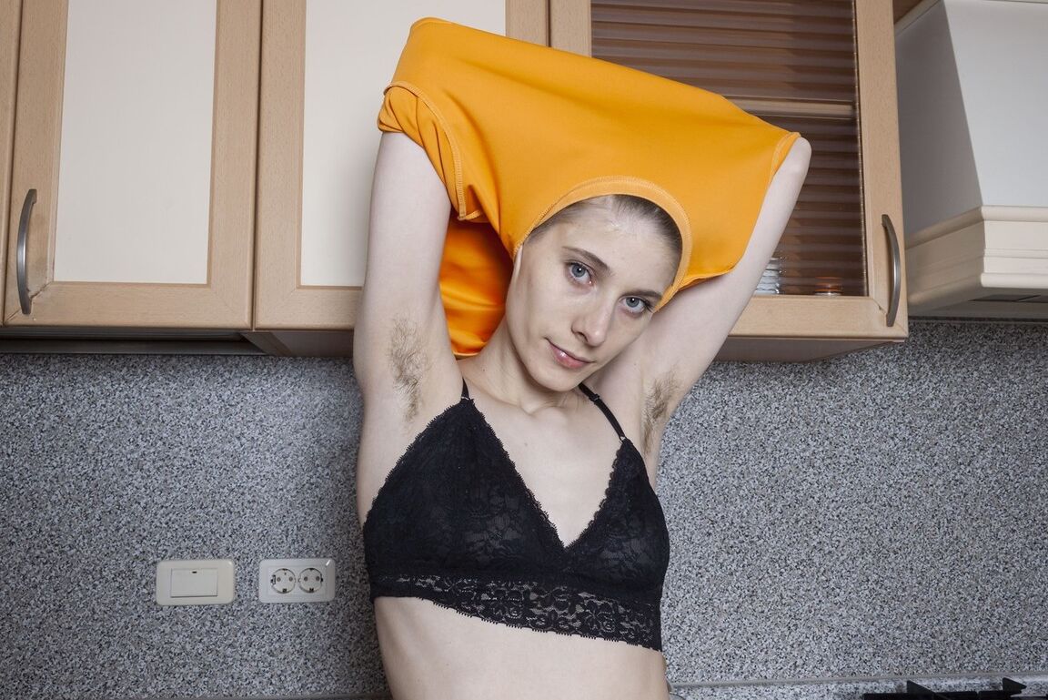 16P A garota de cabelos curtos Amelinda exibe suas axilas peludas e seu arbusto em uma cozinha