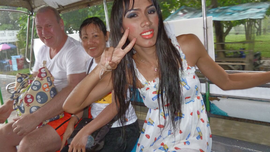 17P Ladyboy asiático de cabelos compridos mostra um pequeno pau andando por locais públicos