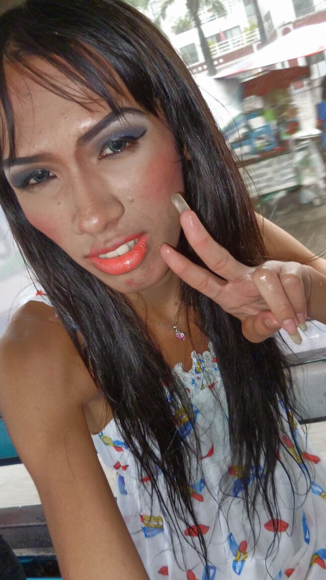 17P Ladyboy asiático de cabelos compridos mostra um pequeno pau andando por locais públicos