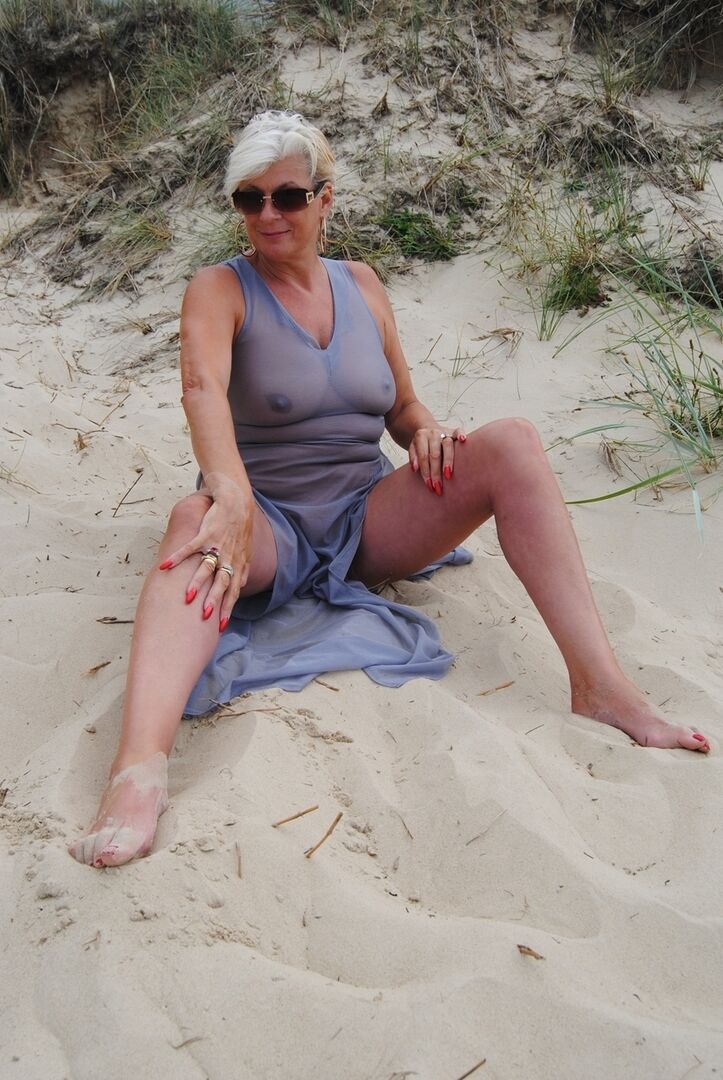 20P Older blonde amateur Dimonty models at the beach in see thru attire and shades