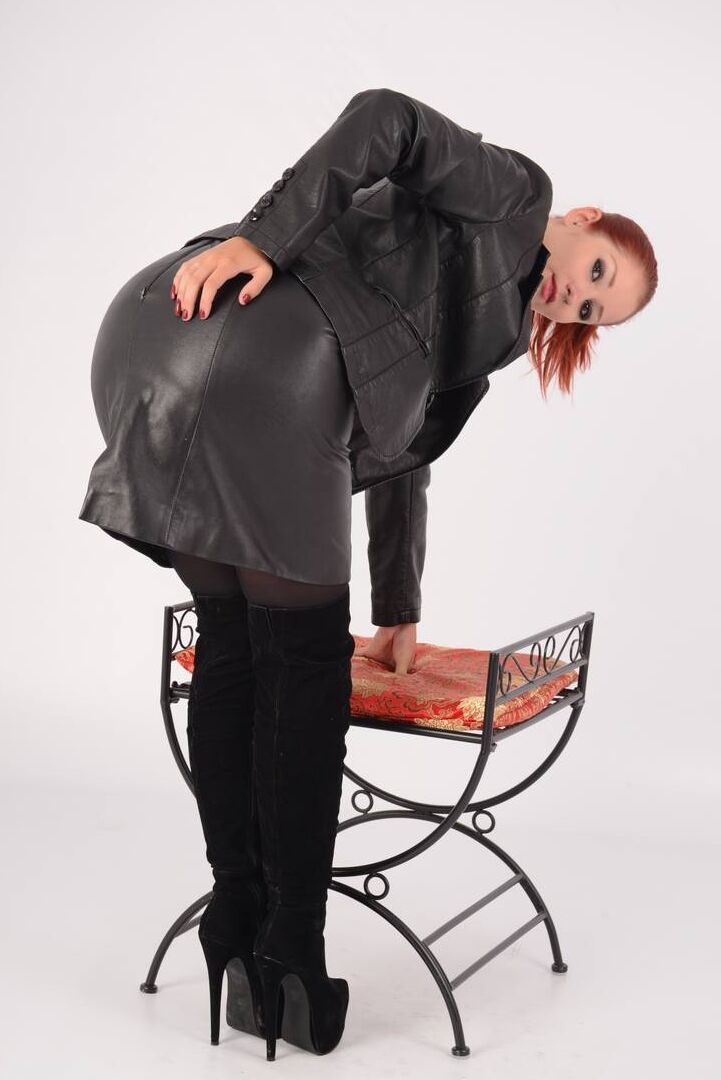 15P Hot redhead Harley frees big naturals from leather in jacket in matching skirt