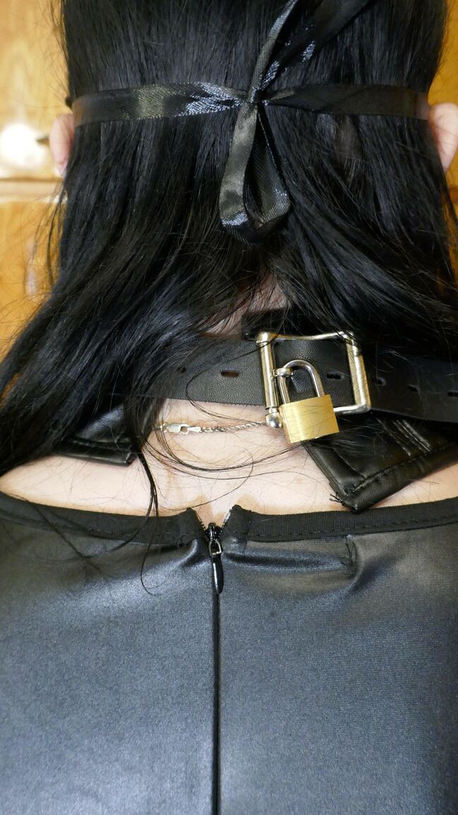 16P Une femme solo à collier modèle des vêtements en cuir tout en portant un masque
