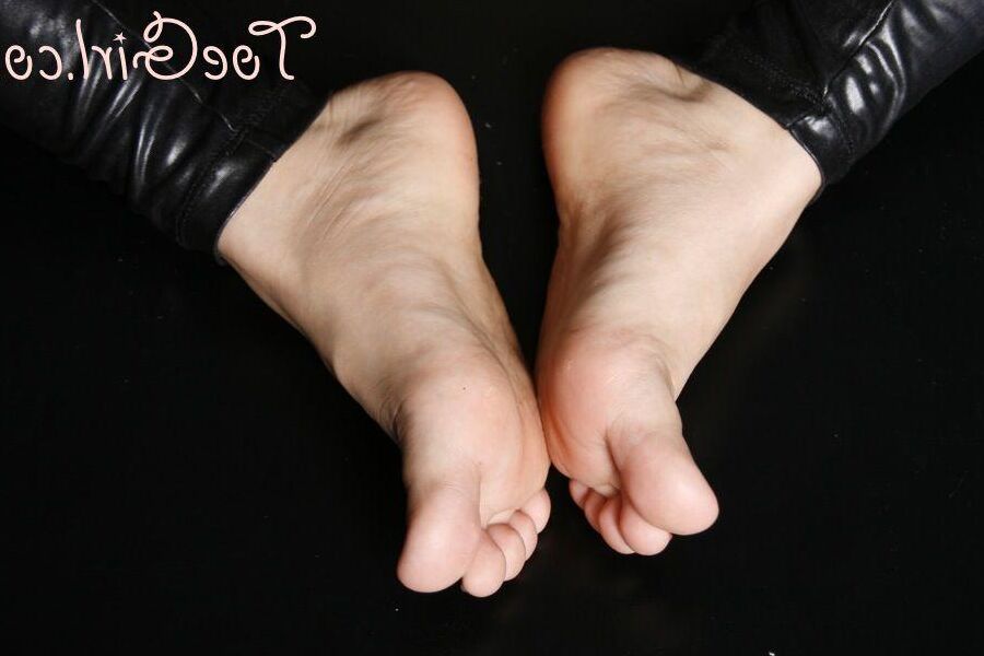 16P Une femme de race blanche affiche ses ongles peints tout en portant un pantalon en cuir