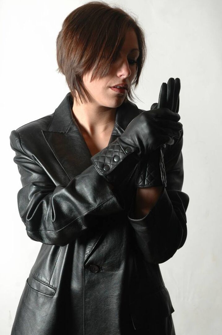 15P Fully clothed female pulls on a pair of black leather gloves