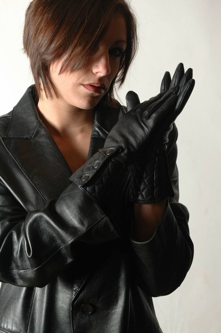 15P Fully clothed female pulls on a pair of black leather gloves