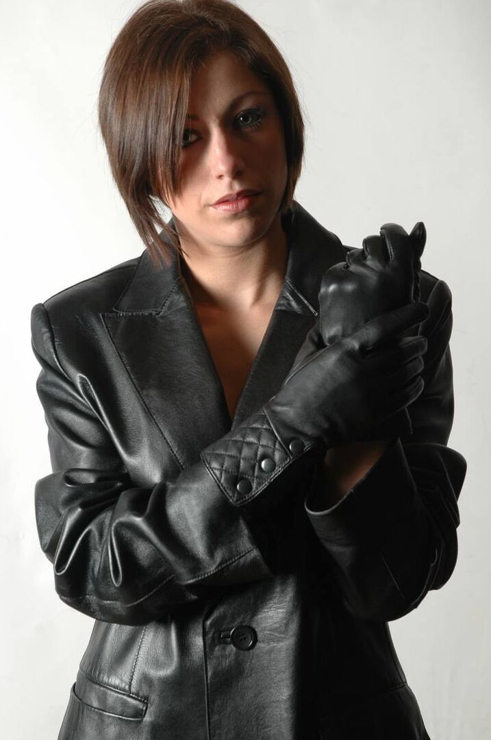 15P Fully clothed female pulls on a pair of black leather gloves