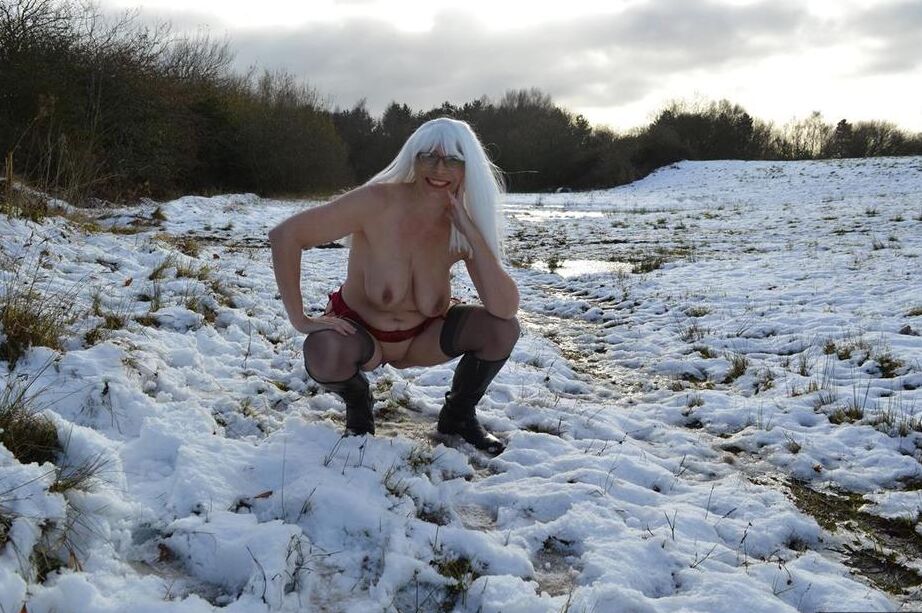 20P Madura rubia platino se desnuda en un suelo cubierto de nieve con botas negras