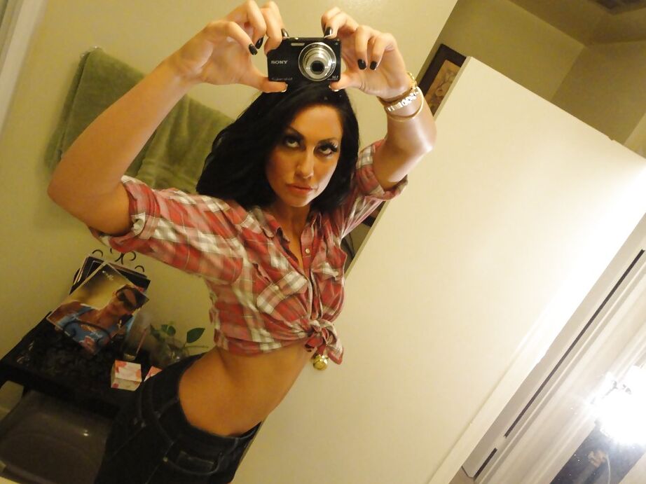 16P La salope brune Tiffany Brookes prend des photos dans un miroir en se déshabillant.