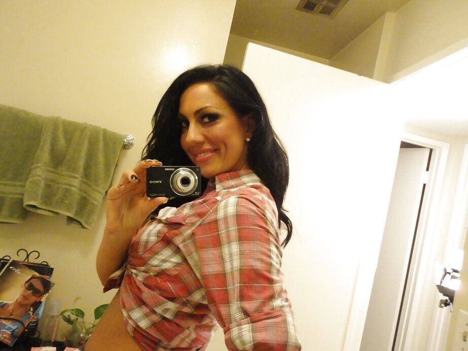 16P La salope brune Tiffany Brookes prend des photos dans un miroir en se déshabillant.