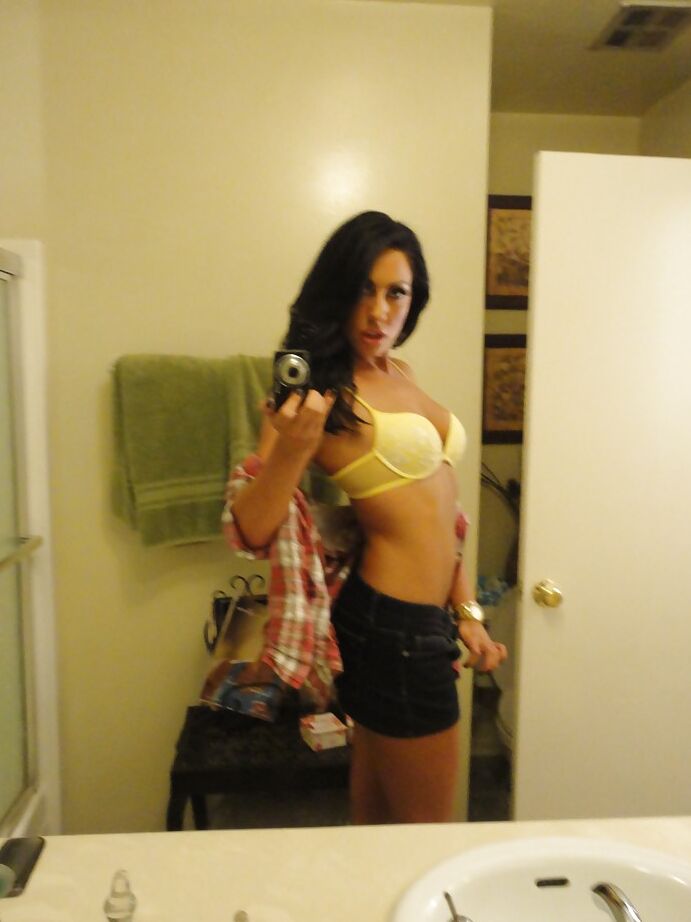 16P La salope brune Tiffany Brookes prend des photos dans un miroir en se déshabillant.