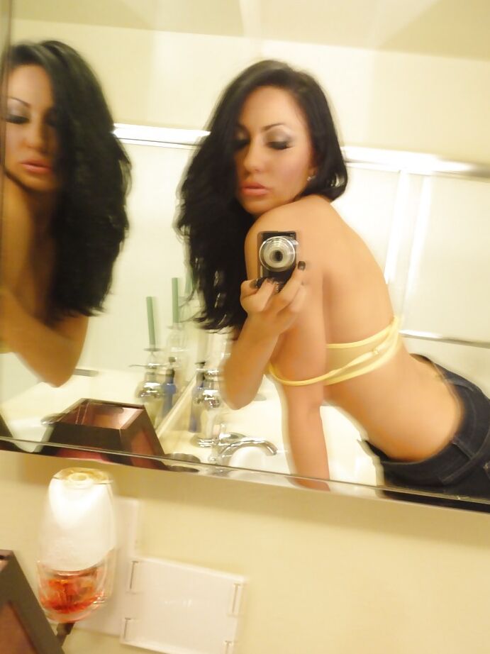 16P La salope brune Tiffany Brookes prend des photos dans un miroir en se déshabillant.