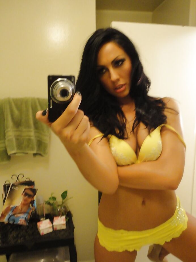 16P La salope brune Tiffany Brookes prend des photos dans un miroir en se déshabillant.