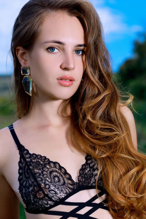 18P A modelo adolescente Hailey remove três peças de lingerie preta e meias em um campo